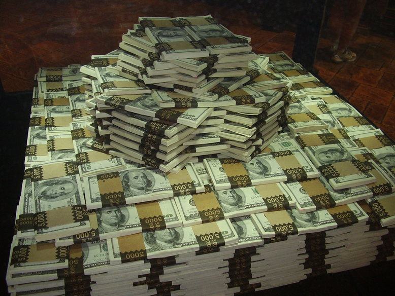 A stack of 100-dollar bills. Averages describe the program, not your individual benefit. Photo: Wikimedia Commons, CC BY-SA 3.0.